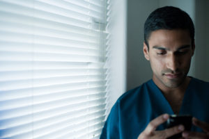 Young male doctor using pager a male doctor using pager by the window