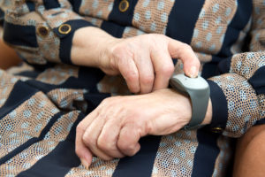 Emergency call system a senior woman pushing the emergency button of the device for professional help